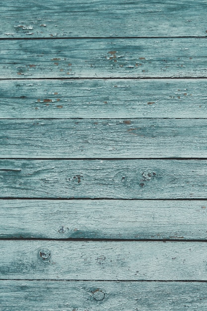 Old green shabby wooden planks with cracked color paint