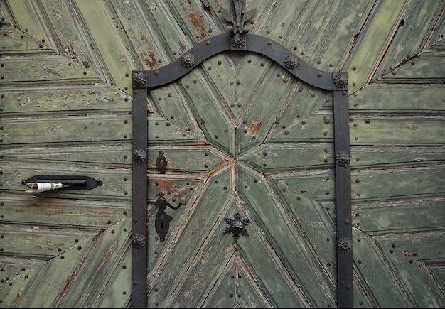 Old green wooden door gate closeup fragments of architecture of ancient buildings Green wood texture