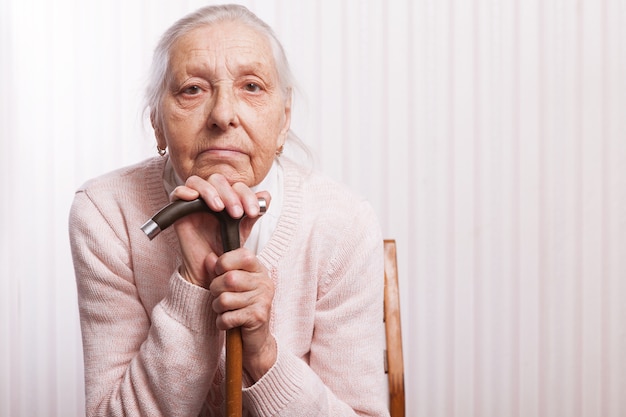 Old hands. An elderly woman sits cross-arms at home