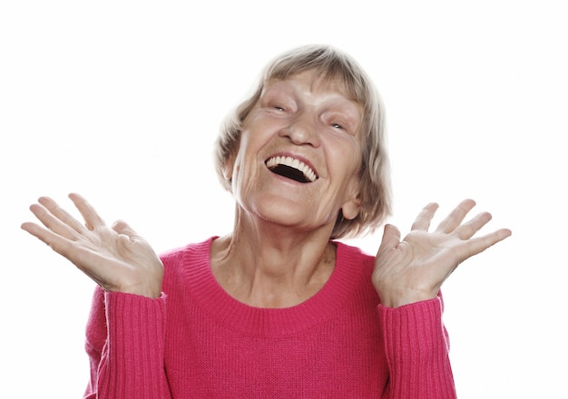 Old happy surprised woman over white wall, lifestyle concept