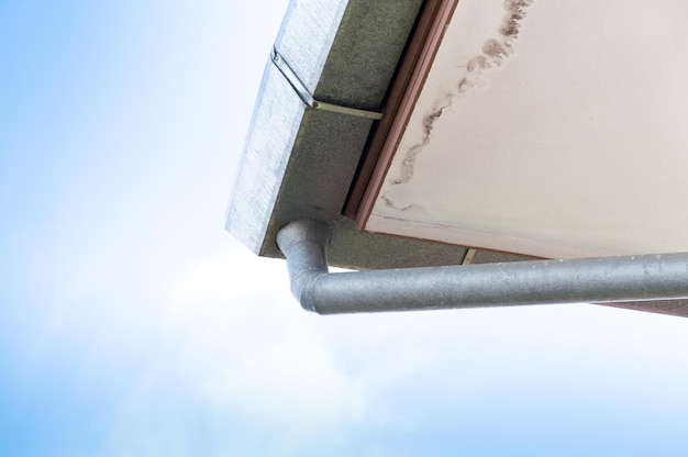 Old house trough on roof and blue sky,Rain gutters on a home