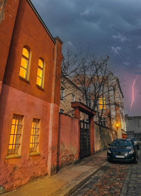 Old houses in Old Town of Klaipeda, Lithuania illuminated by lanterns and windows in a thunderstorm