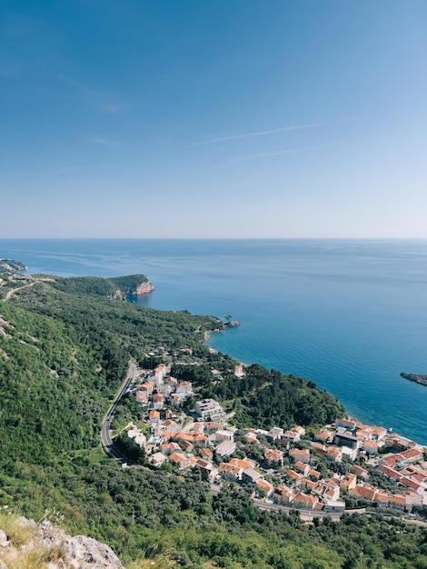 Old houses with red roofs at the foot of the mountains on the adriatic sea