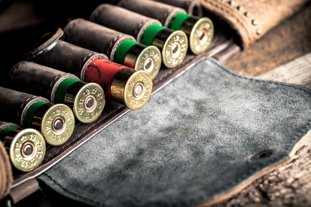 Old hunting cartridges and bandoleer on a wooden table