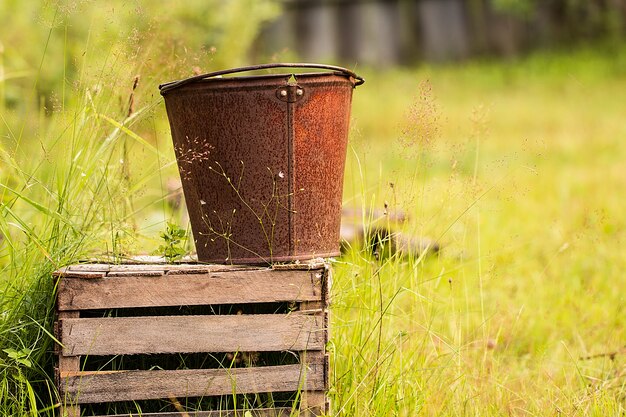 An old iron bucket at wooden pallet