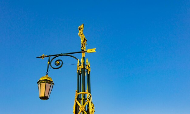 An old lantern on the street against the blue sky.