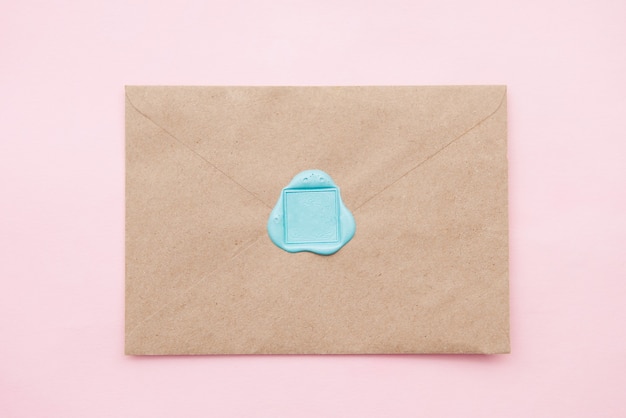 Old letter envelope with wax seal on pink background