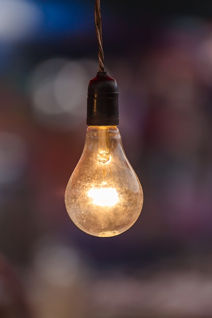 Old light bulb glowing close up