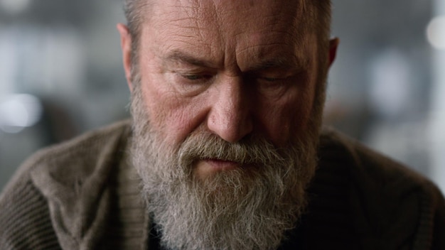 Old man face closeup Portrait senior man thinking strategy game at home Closeup thoughtful mature model face looking down in luxury interior Focused retired man playing board game Wisdom concept