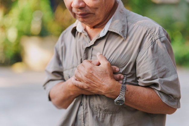 An old man holds his chest in pain Concept of heart disease