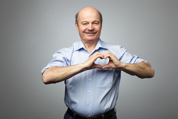 Old man making out of hands heart Doing charity work take care of the health or being in love