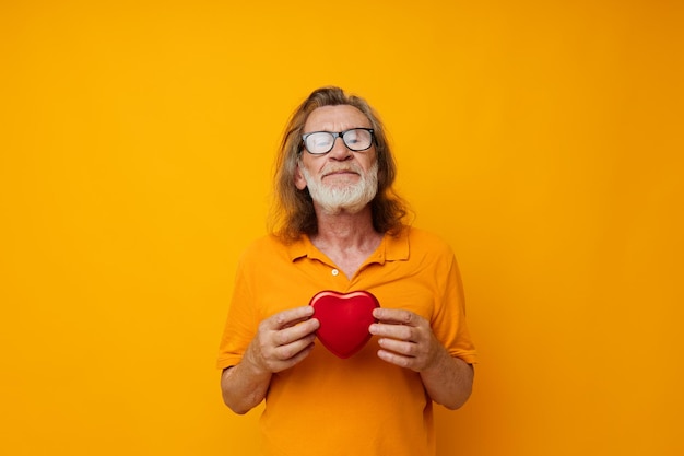 Old man yellow tshirt and glasses posing heartshaped box cropped view