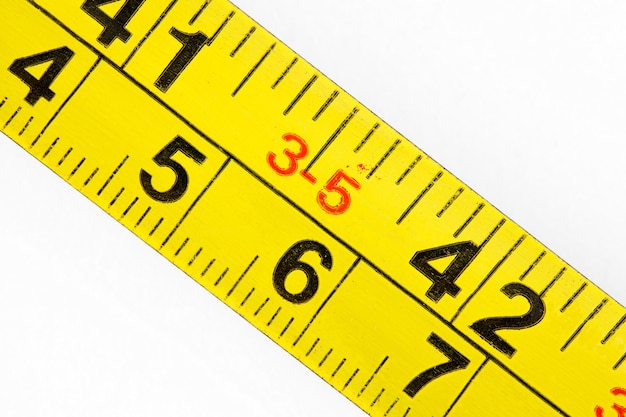 Old measuring tape measure scale in millimeters and inches, macro close-up