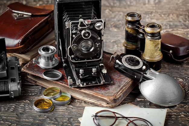 Old mechanical photo camera on an old background