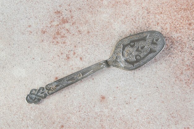 Old metal cake spatula on concrete table.