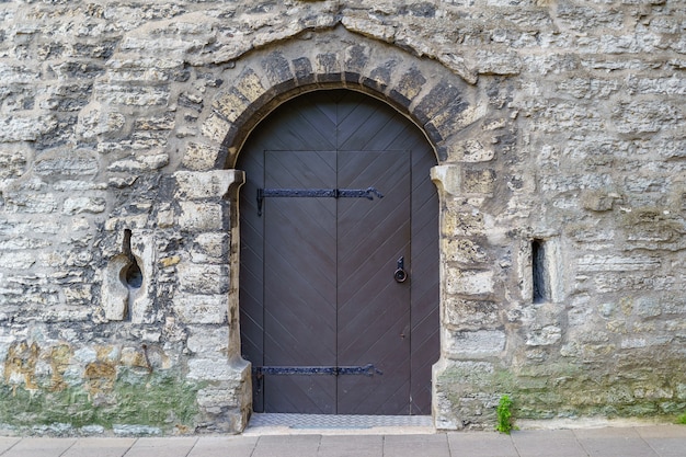 Old metal door in medieval castle facade.