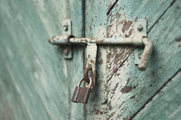 Photo old metal lock on a wooden door with cracked paint