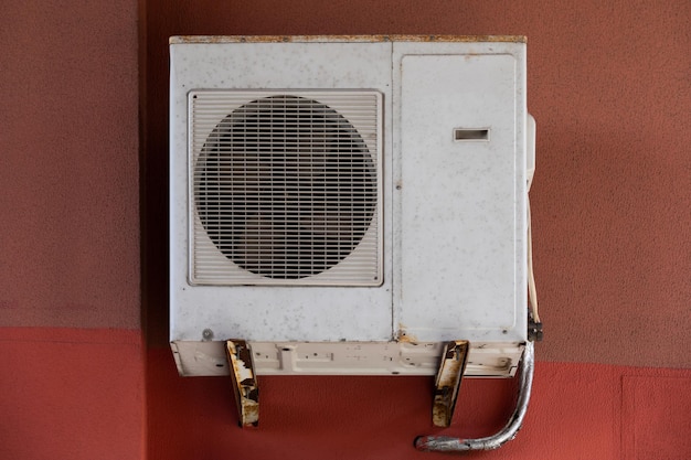 Old outdoor air conditioner unit hanging outside the building