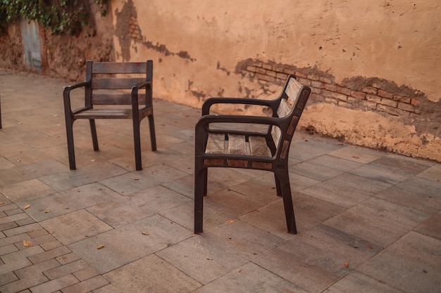 Old outdoor seating chairs near the old building wall Barcelona Catalonia Spain Europe High quality photo