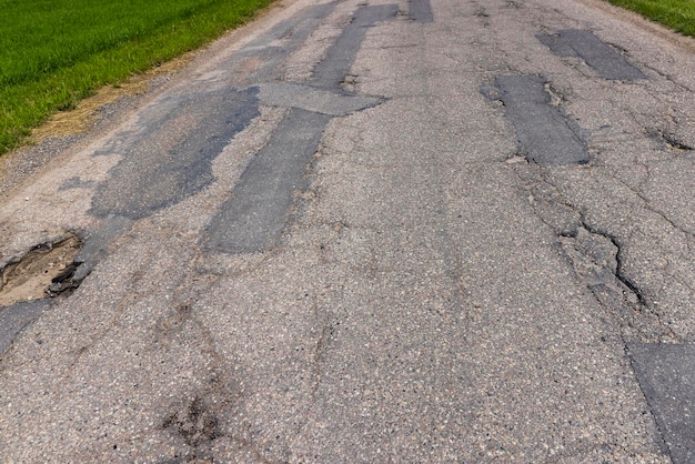 An old paved road with a lot of holes and damage