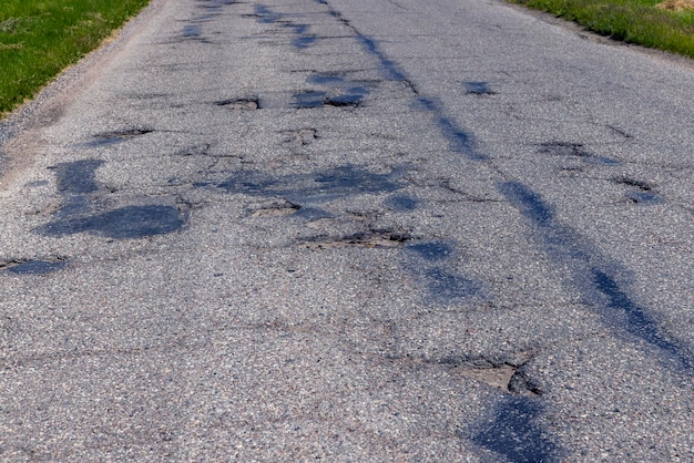 An old paved road with a lot of holes and damage