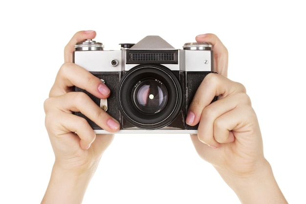 Old photo camera in hands isolated on white