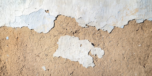 Old plastered wall background Texture of the old peeling cracked weathered plaster with chips