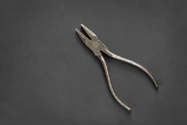 Old pliers on black background