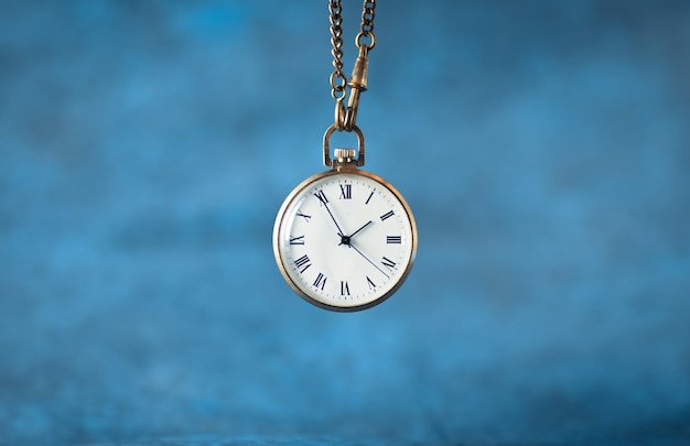 Old pocket watch on a blue background