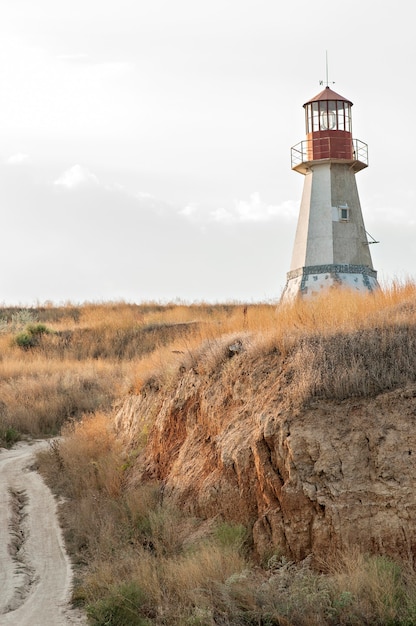 Old red lighthouse on a hill of dry straw