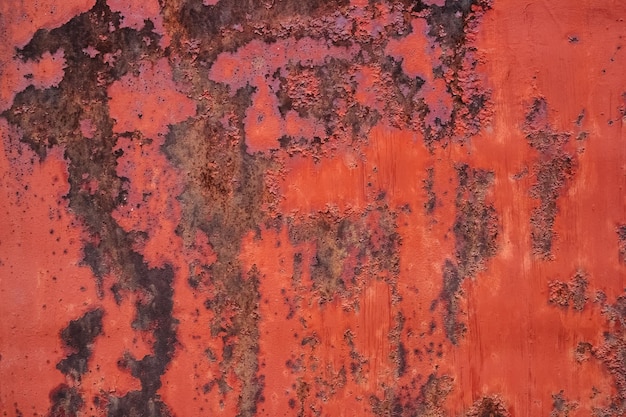 Old red painted metal surface with extensive corrosion spots background