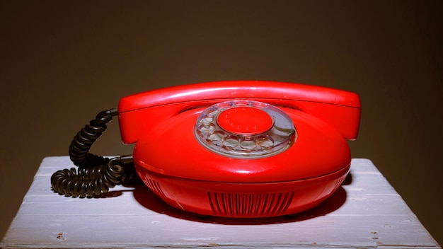 Old red vintage phone on a white chair stool