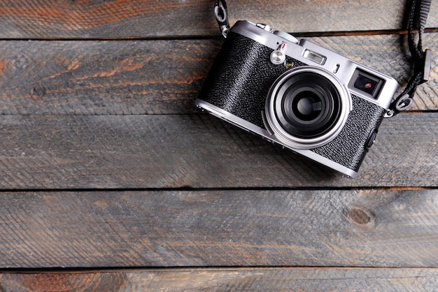 Old retro camera on rustic wooden planks background