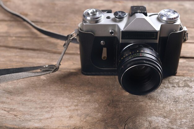 Old retro camera on rustic wooden planks background