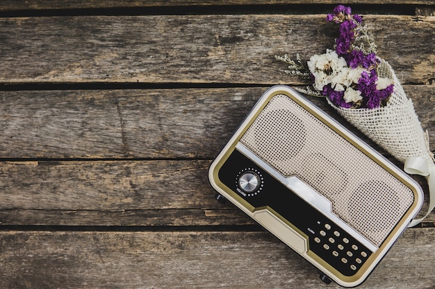 The old retro radio is paired with dried flowers on old wooden floor