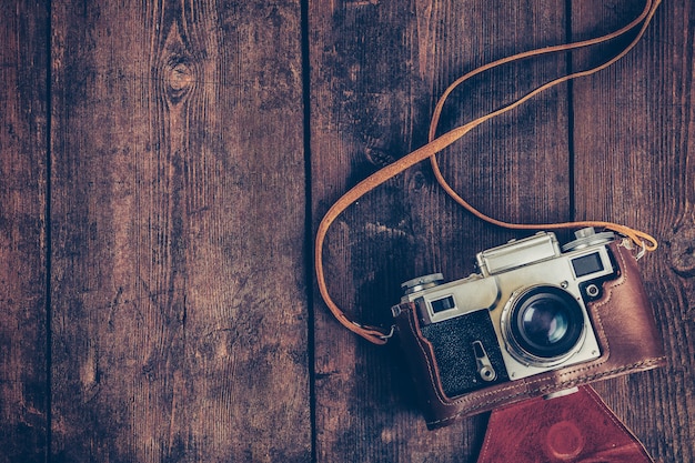 Old retro vintage camera on grunge wooden background