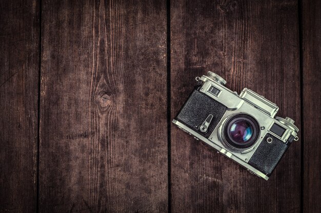 Old retro vintage camera on grunge wooden background