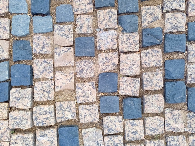 Old road pavement with granite stones. Paving stones.