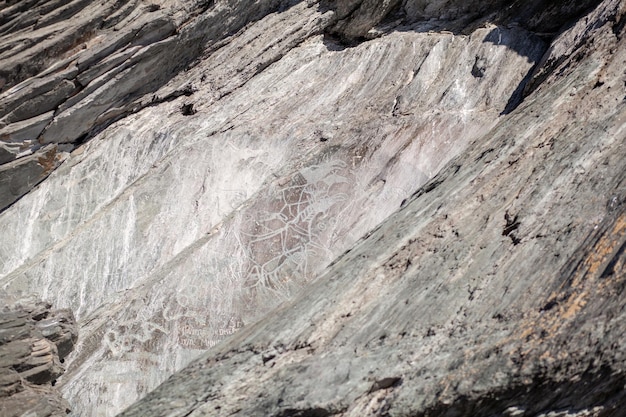 Old rock carvings of an ancient man on rocks in Siberia. The drawings depict animals and people