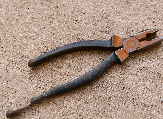 Old round plier tool with brown background