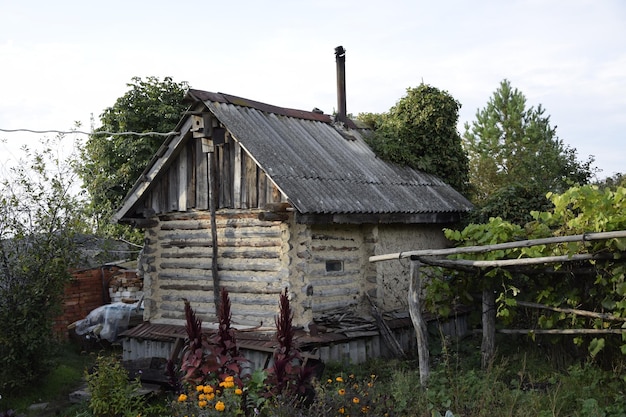 An old ruined wooden farmhouse against a clear sky with clouds Ulyanovsk Russia