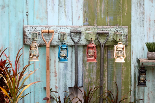 Old rusty kerosene lantern hanged on a rustic wooden wall 