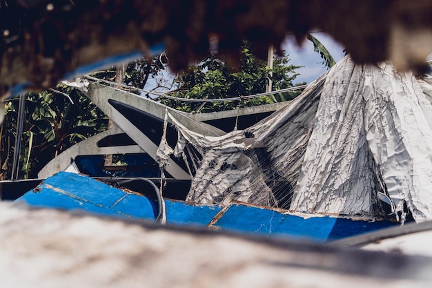 Photo old and rusty motor boats on a landfill surrounded by tropical forest