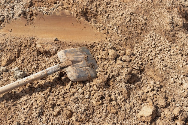 Old rusty shovel in sand on building