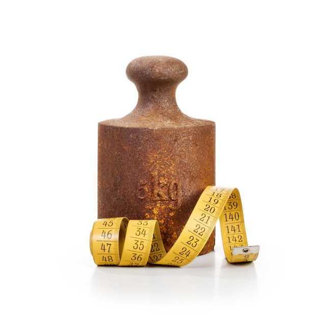 Old rusty weight and tape measure on white background