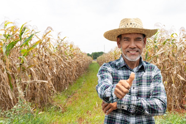 Old senior farmer with white beard thumb up feeling confident