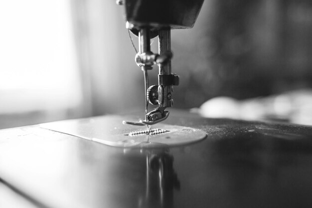 An old sewing machine stands on the table at home ready to work and sew Classic retro style