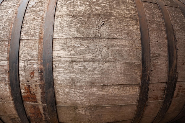 Old shabby wooden oak barrel with rusty steel skids closeup