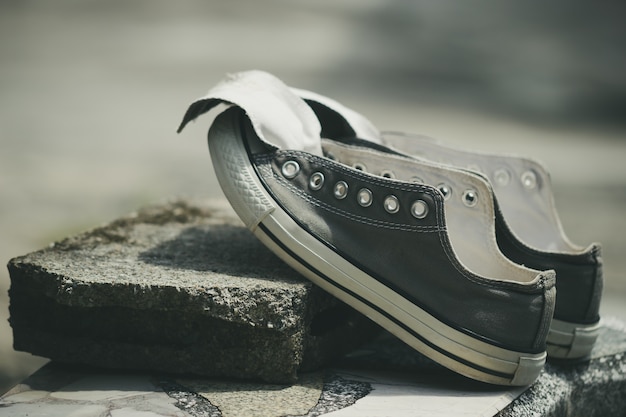 Old sneakers put on a piece of cement in the hot sun.