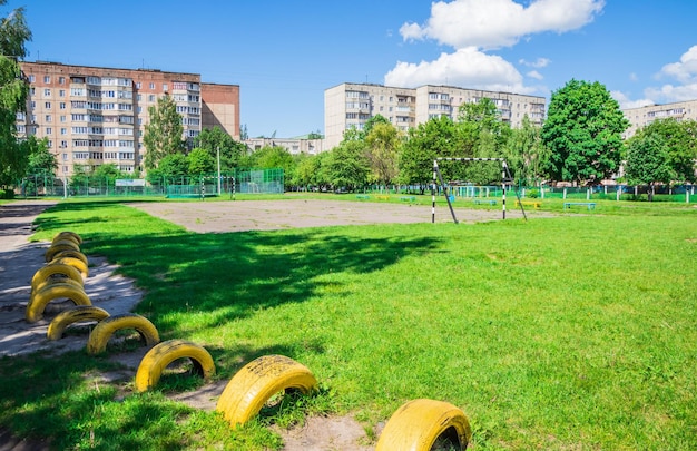 Old soccer field and rusty white soccer goals it the city near t